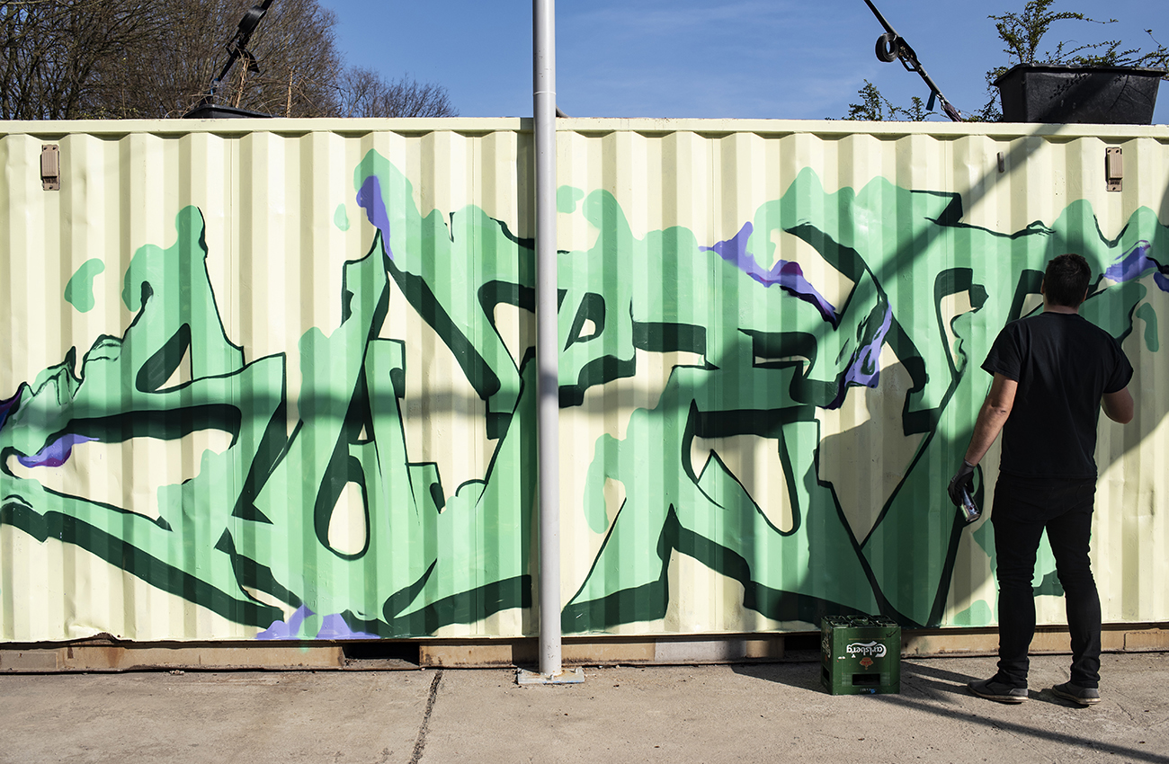 Grafittikünster gestaltet Container